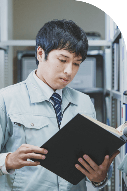 長野県の水と空気を守る中信アスナの社員が、本社資料室で設計書を読んでいる様子